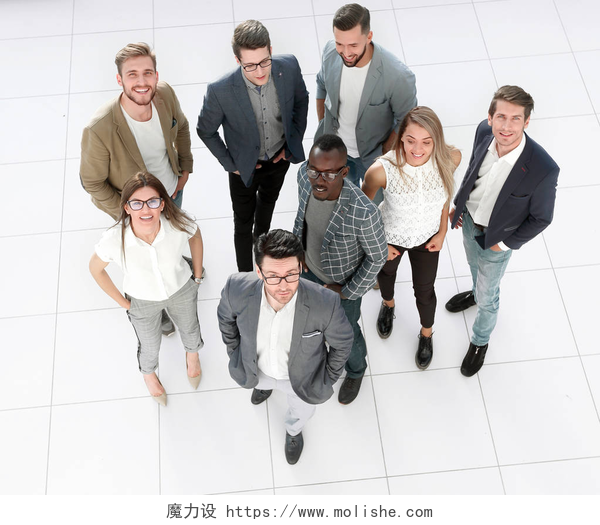 站在白色地板上的年轻人顶部视图。一群有创造力的年轻人站在办公室里.